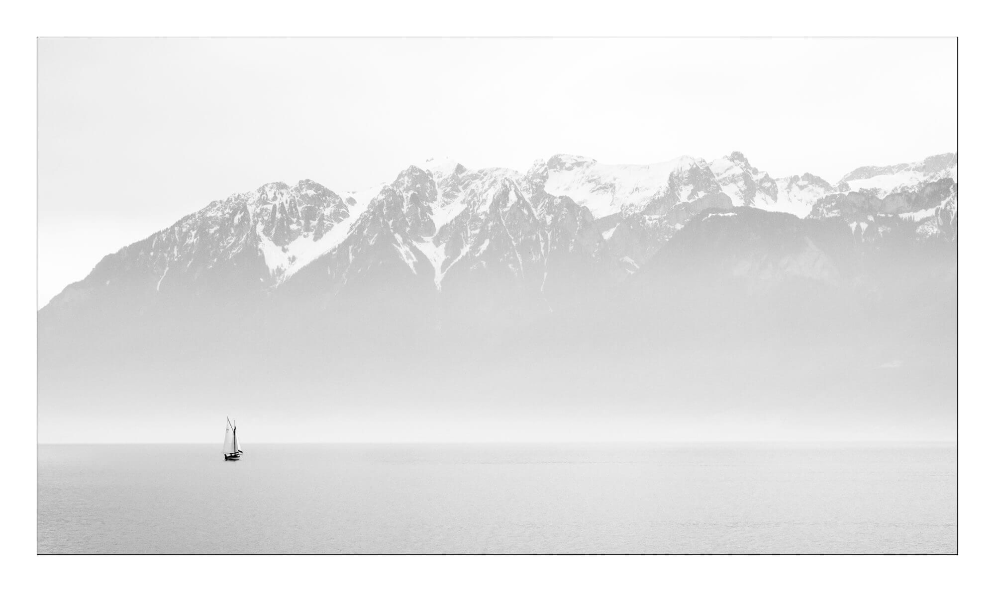 Bateau perdu dans la brume depuis Cully et les montagnes Savoyardes